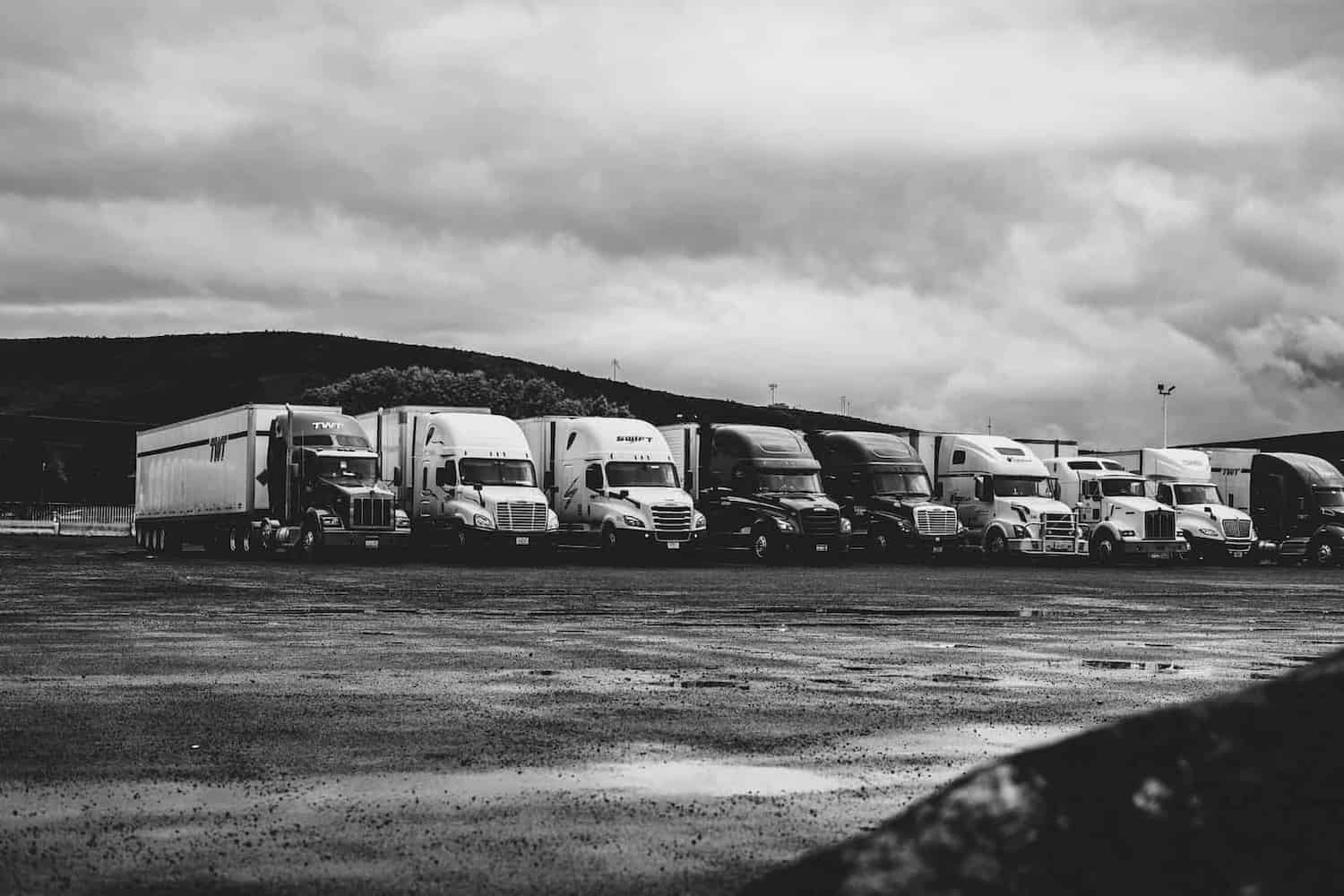 Row of commercial trucks parked in a yard, representing the vehicle and asset finance We Are Finance arranges for businesses